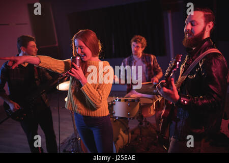 Frau am Mikrofon im Tonstudio singt Stockfoto