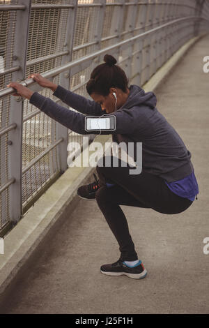 Seitenansicht der jungen Frau, die Ausübung auf Brücke Stockfoto