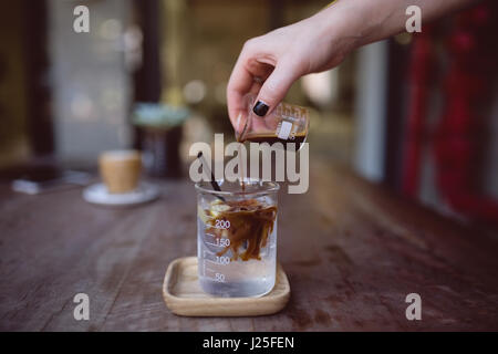 Nahaufnahme des weiblichen Barista Hand strömenden Kaffee im Becher Stockfoto