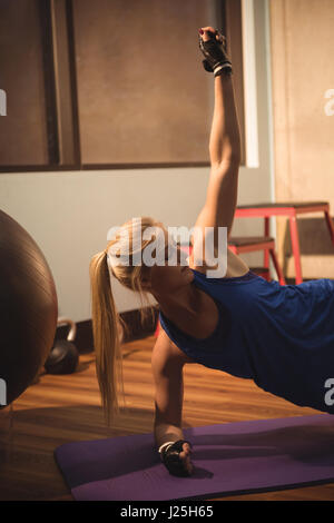 Fit Woman Fitness-Übung durchführen, auf einer Gymnastik Matte in der Turnhalle Stockfoto