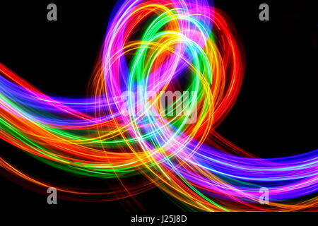 Lange Belichtung Foto von Neon multi-color in eine abstrakte Muster vor einem schwarzen Hintergrund. Licht Malerei Fotografie, abstrakte Farbe Stockfoto