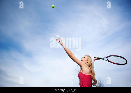 Eine schöne kaukasischen Tennisspielerin er die Kugel auf dem Tennisplatz Stockfoto