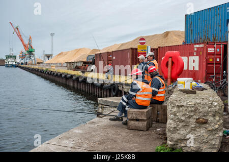 Riga, Lettland - 25. September 2016: Hafenarbeiter in der Freizeit mit Angelrute fangen Fische der Hafenkanal. Stockfoto