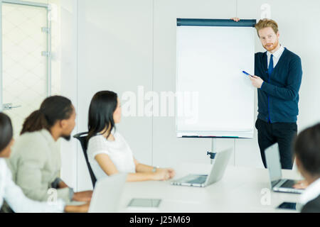 Junge Geschäftsleute an einem Konferenztisch sitzend und zu den Dozenten zuhören und lernen neue Technologien aus den Leacturer gerichtet ist Stockfoto