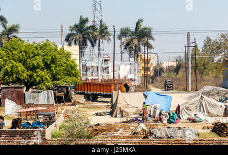 Einheimischen Frauen arbeiten bei einer streckenseitigen Gehöft auf der Kathgodam in Delhi Zeile pats Kuh Trocknung unter freiem Himmel, Rampur, Uttar Pradesh, Nordindien Stockfoto