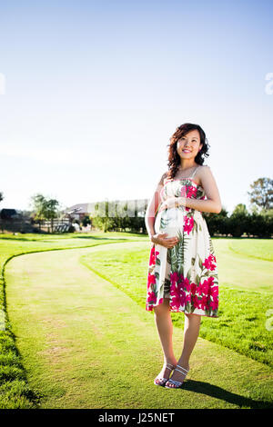 Ein Porträt einer asiatischen Schwangeren im freien Stockfoto