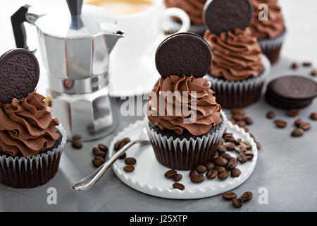 Schokoladen-Kaffee-Cupcakes mit dunklen Glasur dekoriert mit Sandwich-Plätzchen Stockfoto