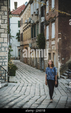 Junge Frau zu Fuß entlang Stein Straße, Vis, Kroatien Stockfoto