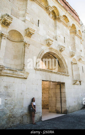Junge Frau, die alte steinerne Wand gelehnt, Split, Kroatien Stockfoto