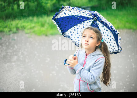 Porträt von einem netten traurige Mädchen mit einem Regenschirm im Regen. Stockfoto