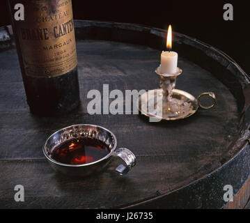 Französischer Rotwein Verkostung Keller Sommelier Sachverständige Situation mit 1964 Flasche Château Brane-Cantenac auf Fass mit tastevin und Kerze Margaux Frankreich Stockfoto