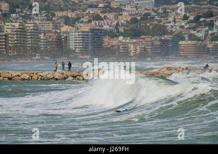 Surfer, Surfen, Surfer nutzt die hohe Wellen. Fuengirola, Malaga, Andalusien, Spanien, 2016. Code Orange ist für hohe Wellen und Wind gegeben. Stockfoto