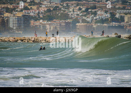 Surfer, Surfen, Surfer nutzt die hohe Wellen. Fuengirola, Malaga, Andalusien, Spanien, 2016. Code Orange ist für hohe Wellen und Wind gegeben. Stockfoto