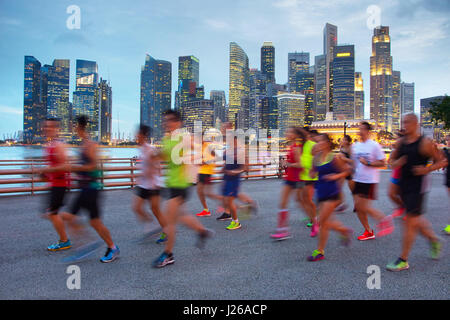 Gruppe von Läufern auf Singapur Kai in der Dämmerung Stockfoto