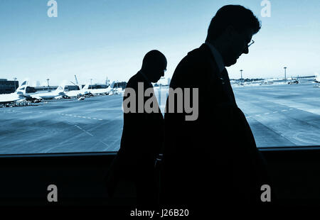 Silhouette von zwei Geschäftsleute zu Fuß durch den Flughafen Narita in Tokio, Japan Stockfoto