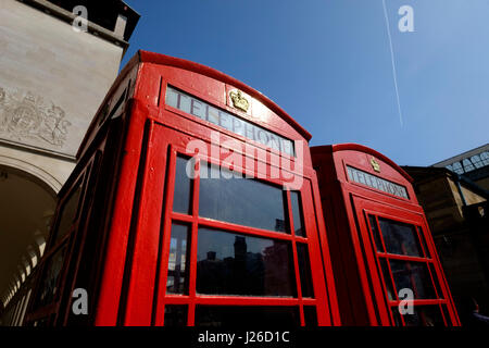 Low Angle Shot aus zwei roten Telefonzellen gegen den blauen Himmel in London, England, Großbritannien Stockfoto