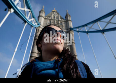 Porträt einer hübschen jungen Frau eine Sonnenbrille trug an einem sonnigen Tag, Tower Bridge, London, England, UK, Europa Stockfoto