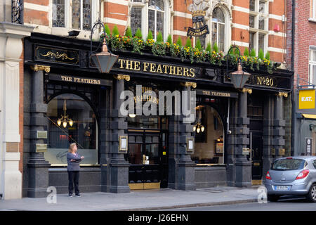 Frau raucht vor The Feathers Pub in London, England, UK, Europa Stockfoto