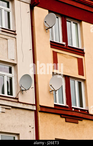 drei Satellitenschüsseln an der Fassade eines Wohnhauses Stockfoto