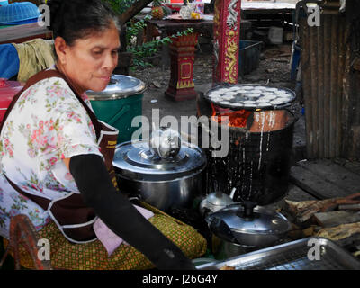 Thai-alte Frauen kochen thai Imbiss ist Khanom Khrok Kokosmilch mischen mit Pulver für Verkauf Menschen am market.on 11. April 2017 in auf Pfannkuchen Pfanne gebraten Stockfoto