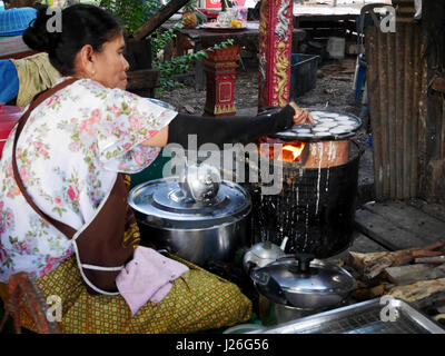 Thai-alte Frauen kochen thai Imbiss ist Khanom Khrok Kokosmilch mischen mit Pulver für Verkauf Menschen am market.on 11. April 2017 in auf Pfannkuchen Pfanne gebraten Stockfoto