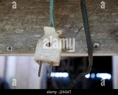 Alten gebrochen elektrische Stecker hängen im Haus am Land von Thailand Stockfoto