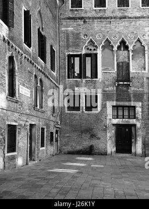 Mittelalterlichen Innenhof in Venedig mit alten Windows repariert Wände und Türen Stockfoto