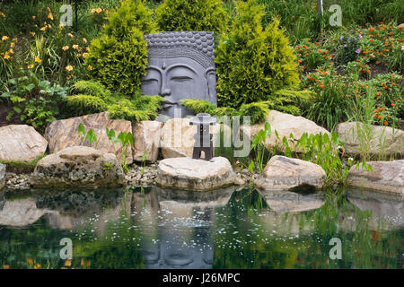 Teich mit großen gemeißelten Kopf in den Zen Garten an der Route des Gerbes d'Angelica Garten im Sommer, Mirabel, Laurentians, Quebec, Kanada Stockfoto