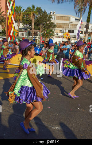 Mitglieder von einem Pueblo tanzen Gruppe in reich verzierten Kostümen erklingt in der jährlichen Carnaval Andino Con la Fuerza del Sol in Arica, Chile. Stockfoto