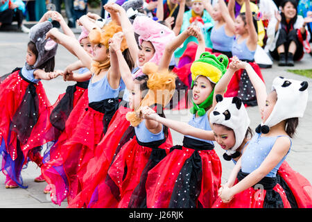 Japan, Kumamoto, Hinokuni Yosakoi Festival. Kinder Girl's Dance Team, verkleidet als Feen in Rot zogen die Kostüme mit tierischen Hüte. Tanz im Freien. Stockfoto