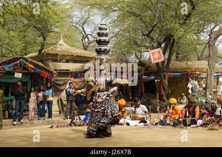 Tribal Tänzerin, die Durchführung einer Tanz während Ausgleich Töpfe auf dem Kopf auf der Sarujkund Messe in der Nähe von Delhi, Indien Stockfoto
