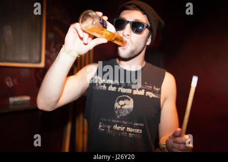 Junger Mann, ein Bier trinken Stockfoto