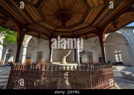 SARAJEVO, Bosnien-Herzegowina - 17. April 2017: Brunnen von Gazi Husrev Begova Moschee mit Menschen beten im Hintergrund. Die Moschee ist eines der m Stockfoto