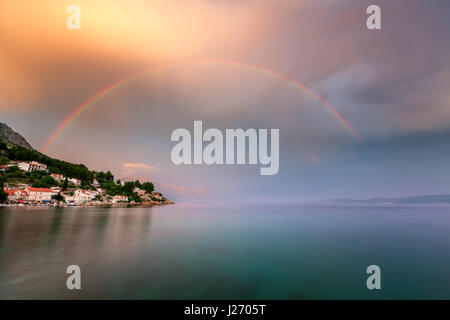 Regenbogen über dem kleinen Dorf in Omis Riviera nach dem Regen, Dalmatien, Kroatien Stockfoto