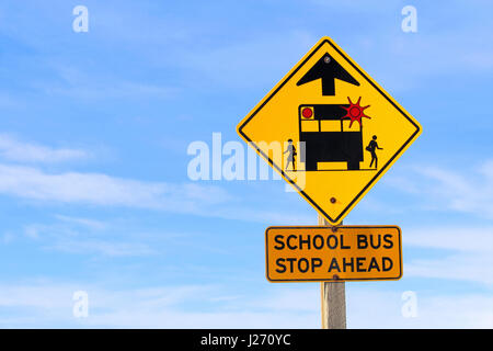 Nahaufnahme eines Schulbusses Stoppschild voraus vor blauem Himmel Stockfoto