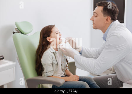 Aufmerksame HNO-Arzt Hals Prüfung tun Stockfoto