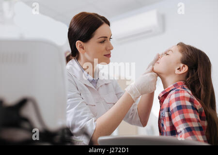 Aufmerksame HNO-Arzt Nase Prüfung ihrer Tochter tun Stockfoto