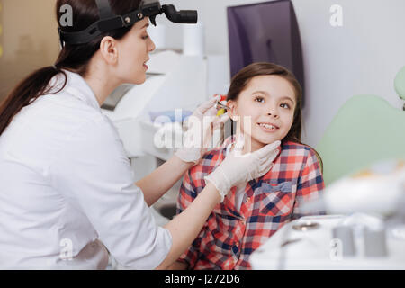 Aufmerksamen Arzt setzen Ohr-Trichter ins Ohr ihrer Patientin Stockfoto