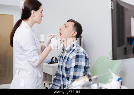 Aufmerksame HNO-Arzt Hals Prüfung tun Stockfoto