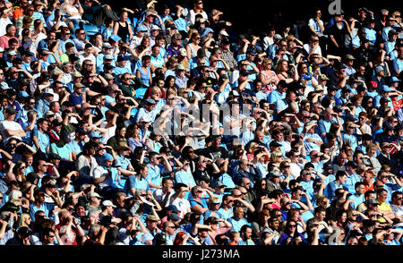 Fans zu schützen ihre Augen vor der Sonne während der Premier-League-Spiel im Etihad Stadium Manchester. Stockfoto