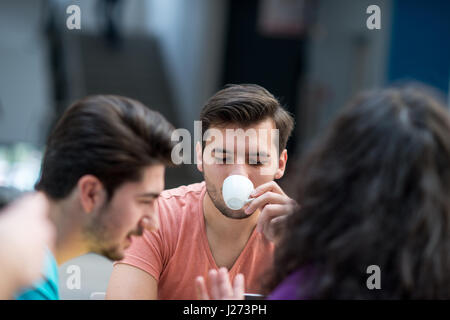 Eine Gruppe von Jugendlichen am Tisch im Café sitzen, mit Laptop und trinken Orangensaft. Stockfoto