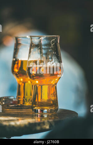 Zwei Gläser Bier auf einem Tisch in einem Straßencafé, Tiefenschärfe, vertikale Zusammensetzung Stockfoto