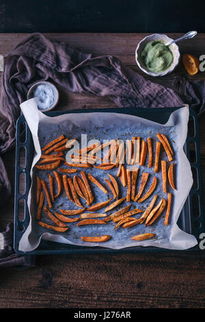 Ofen gebackene Süßkartoffel-Pommes auf ein Backblech Stockfoto