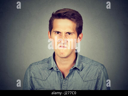 Zorniger junger Mann, Nervenzusammenbruch frustriert auf graue Wand Hintergrund isoliert haben. Negative menschliche Emotion Gesichtsausdruck Gefühle bei Stockfoto