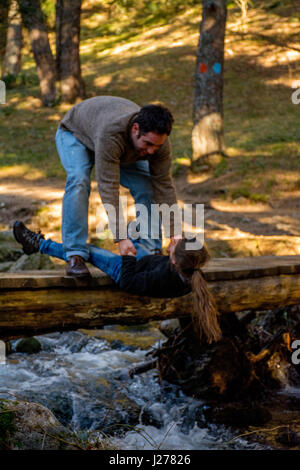 Mädchen in den Fluss fallen wird von ihren großen Bruder gehalten Stockfoto