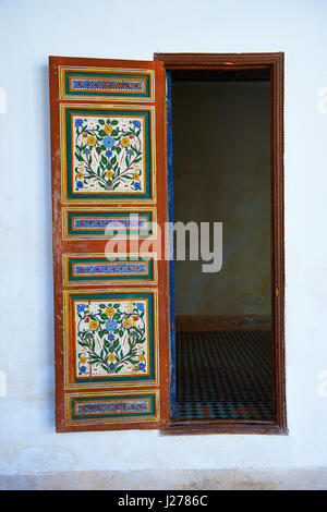 Berber Arabesken bemalte Holztür und Zellige Fliesenboden. Die Petite Gericht, Bahia-Palast, Marrakesch, Marokko Stockfoto