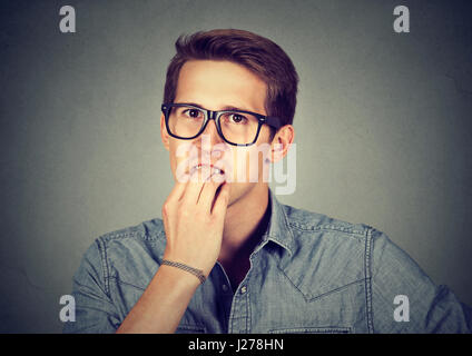 Beschäftigt ängstlichen jungen Mann nervös Fingernägel beißen Stockfoto