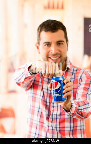 Attraktive Mann Junge lächelnd öffnen eine Pepsi-Cola Stockfoto