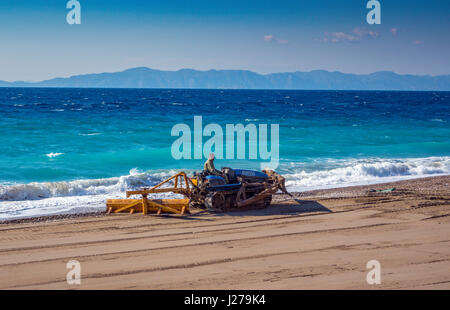 Mann treibende Bulldozer am Strand zu bereinigen, den Sand, Rhodos, Griechenland Stockfoto