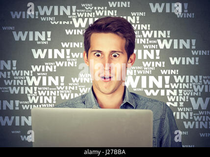 Mann mit Laptop-Computer Bildschirm ungläubig schauen schockiert und überrascht. Stockfoto